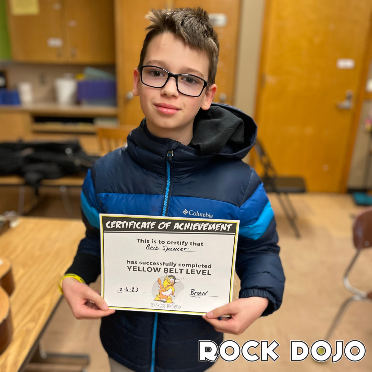 Reid, a ten-year-old student, with his Yellow Belt Certificate from online guitar lessons for kids