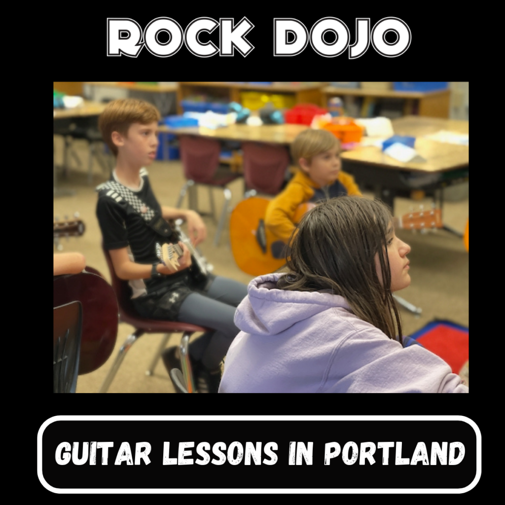 Kids engaged in guitar lessons in Portland at a Rock Dojo after-school class.