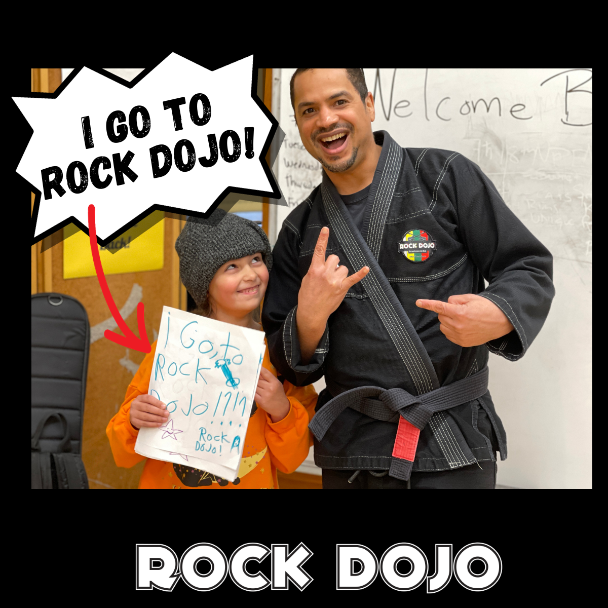 Guitar Sensei standing with a young student at Rock Dojo, who is holding a poster saying 'I go to Rock Dojo!', exemplifying the joy and success in 'Guitar Practice for Kids'.