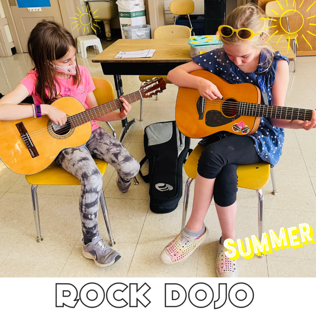  Kids enjoying summer guitar lessons with Rock Dojo, playing acoustic guitars in a classroom setting.